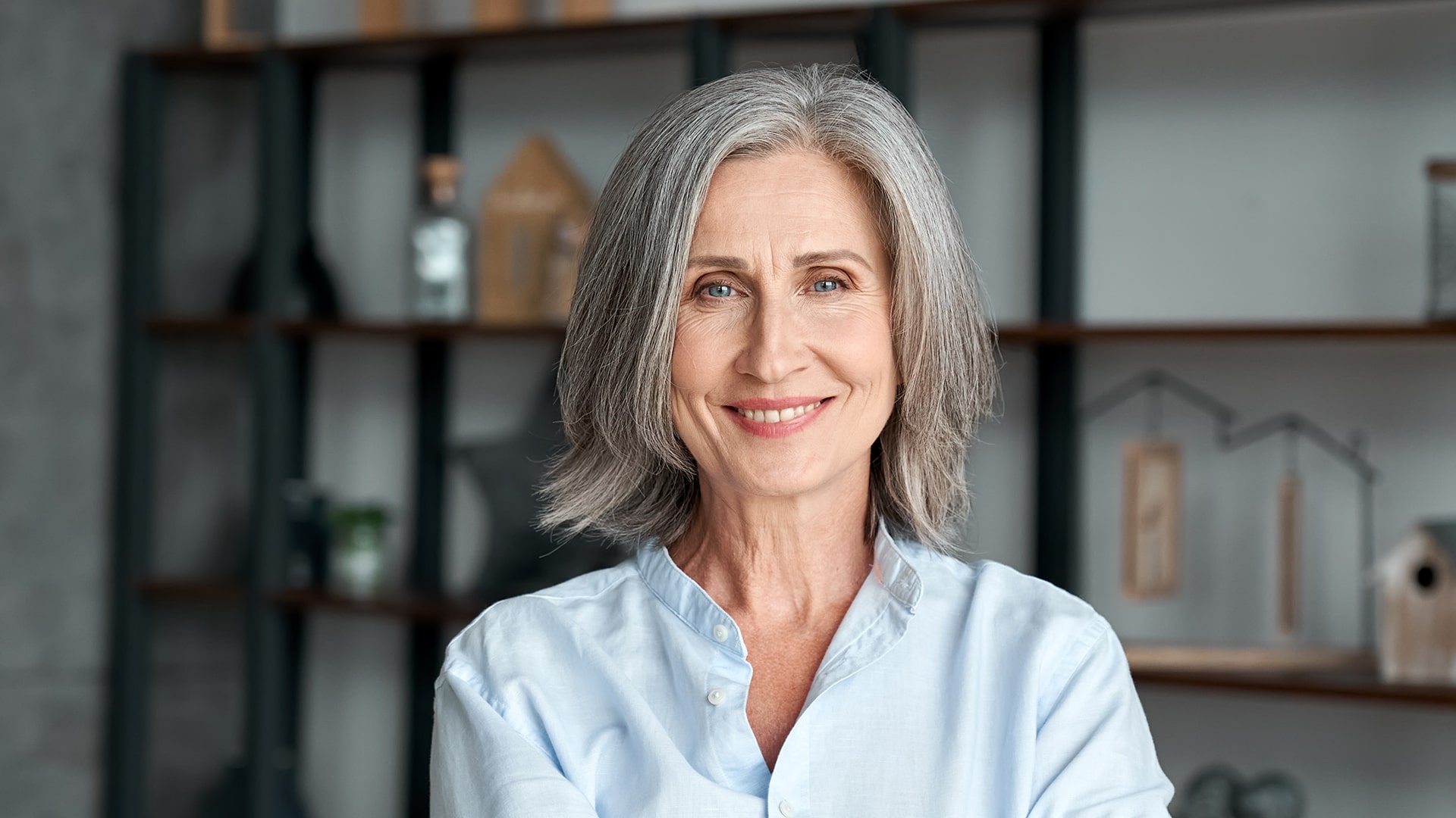 Mature woman confidentially showing off her new cosmetic smile with dental implants
