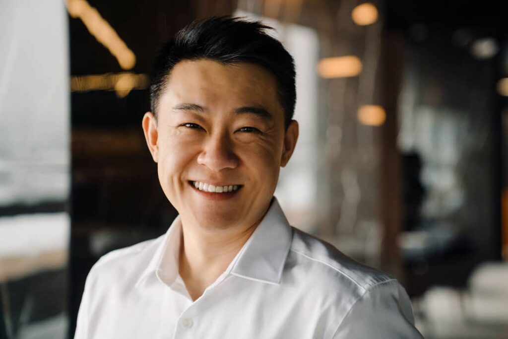 man in white shirt smiling with teeth